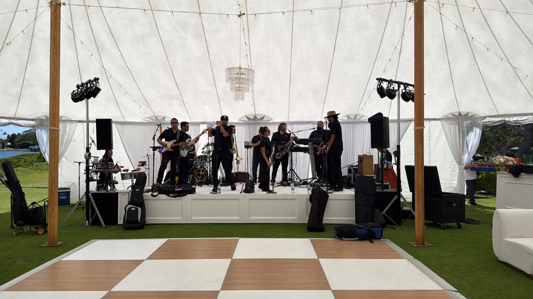 Live band with audio and lighting equipment under an outdoor event tent